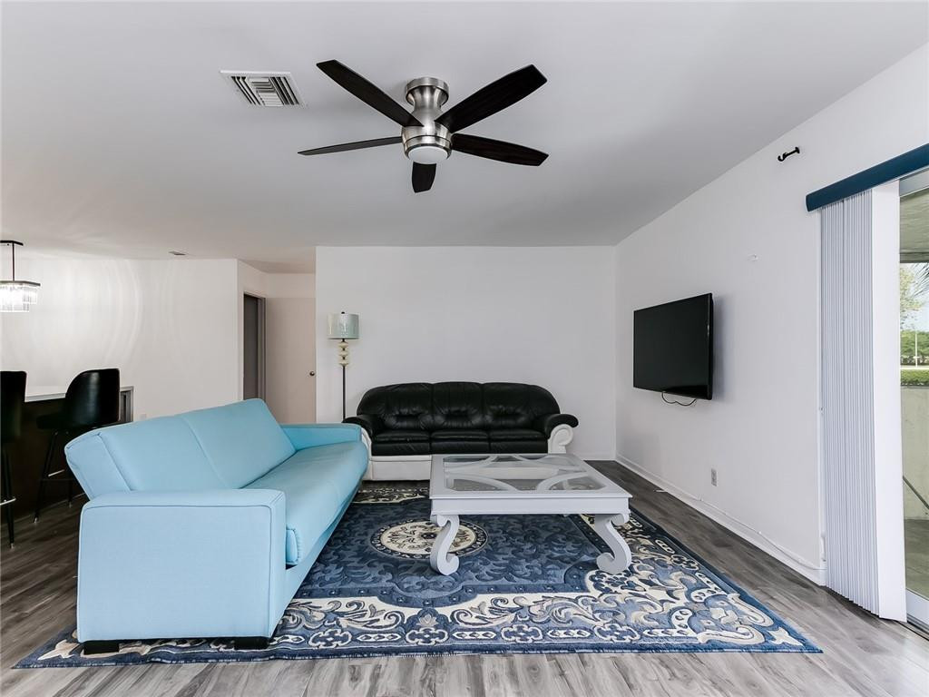 22735 Southwest 66th Avenue, Unit 202 Boca Raton, FL 33428 - Photo 11 of 30 a living room with a couch and a flat screen tv