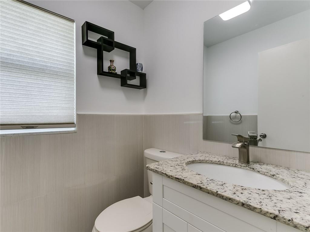 22735 Southwest 66th Avenue, Unit 202 Boca Raton, FL 33428 - Photo 20 of 30 a bathroom with a granite countertop sink and toilet