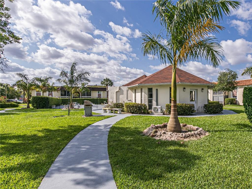 22735 Southwest 66th Avenue, Unit 202 Boca Raton, FL 33428 - Photo 26 of 30 a front view of a house with garden and porch