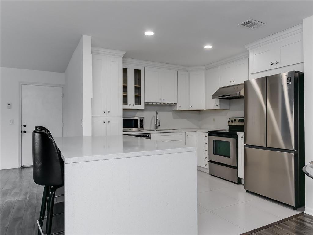 22735 Southwest 66th Avenue, Unit 202 Boca Raton, FL 33428 - Photo 3 of 30 a kitchen with stainless steel appliances a refrigerator sink and microwave