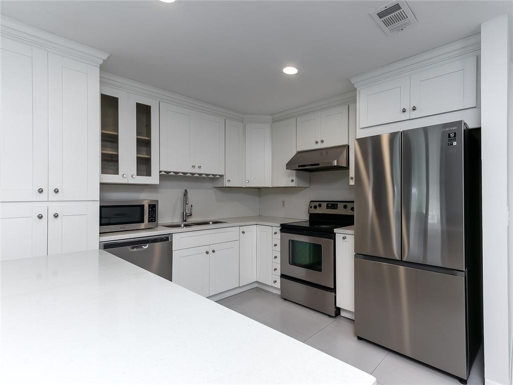 22735 Southwest 66th Avenue, Unit 202 Boca Raton, FL 33428 - Photo 4 of 30 a kitchen with stainless steel appliances granite countertop a refrigerator stove and sink