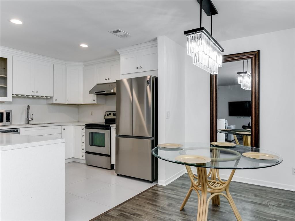 22735 Southwest 66th Avenue, Unit 202 Boca Raton, FL 33428 - Photo 6 of 30 a kitchen with stainless steel appliances a refrigerator stove and sink