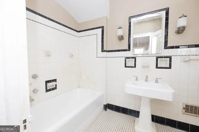 a bathroom with a sink a mirror and a bathtub