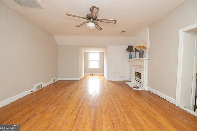 a view of a livingroom with wooden floor and a ceiling fan