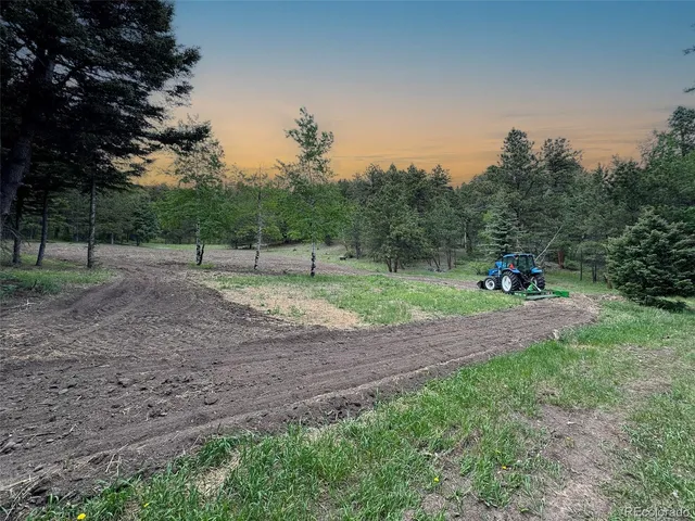 a view of a big yard with mountains in the background