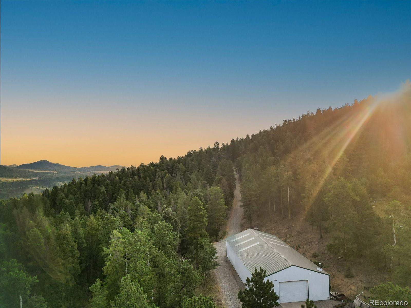 26271 Richmond Hill Road Conifer, CO 80433 - Photo 19 of 50 a view of a big yard with mountains in the background
