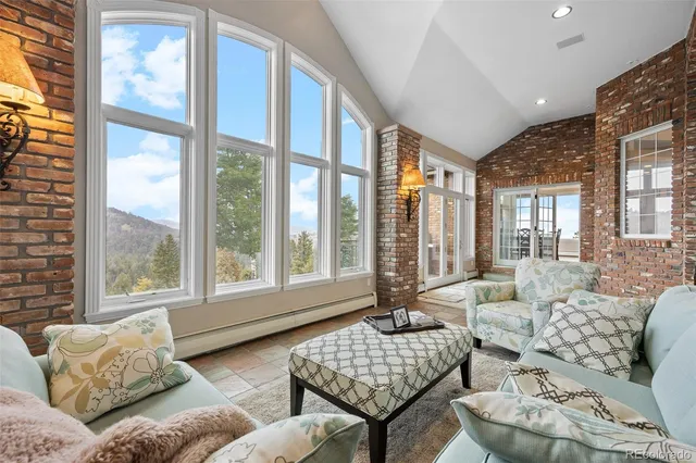 a dining hall with stainless steel appliances granite countertop a couch and wooden floor