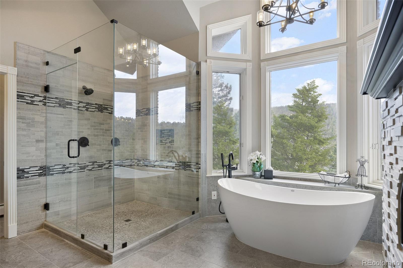 26271 Richmond Hill Road Conifer, CO 80433 - Photo 36 of 50 a bathroom with a tub a sink and glass door