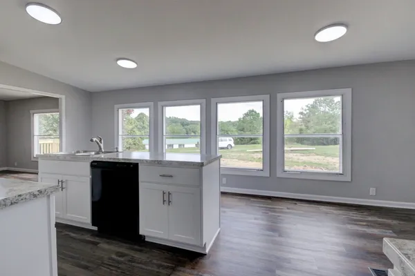 a view of a kitchen with wooden floor and a window