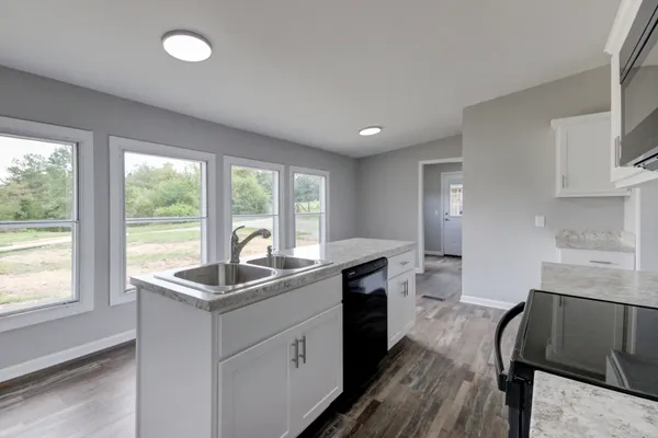 a kitchen with granite countertop a sink and a stove top oven