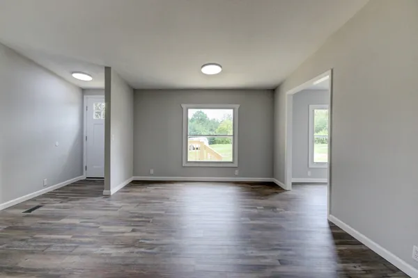 an empty room with a window and a fan