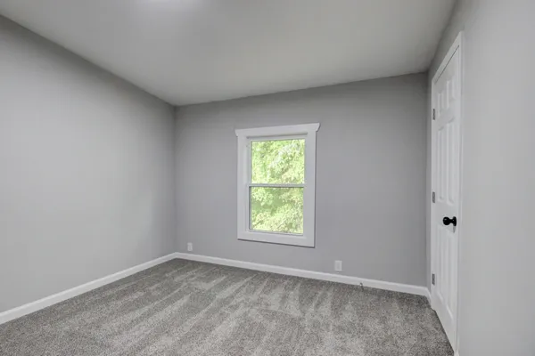 a front view of a house with a yard and trees