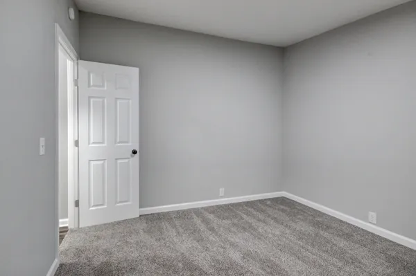 a backyard of a house with lawn chairs and wooden fence