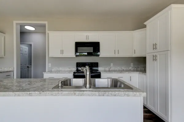 a kitchen with cabinets and wooden floor