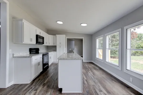 a kitchen with cabinets and wooden floor