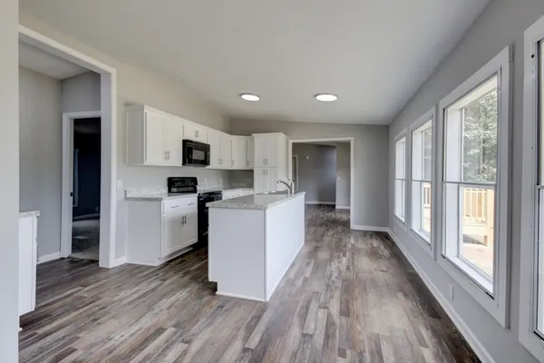 a view of a kitchen with furniture and wooden floor