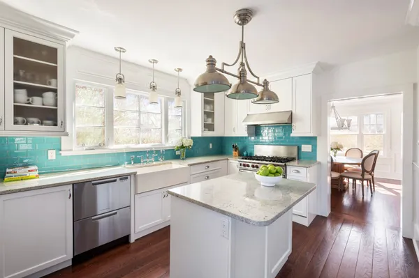 a kitchen with a sink a counter space appliances and cabinets