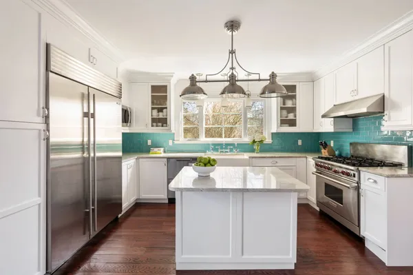 a kitchen with kitchen island a counter top space a sink stainless steel appliances and cabinets