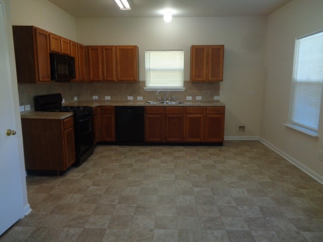 13018 Kingston Point Lane Houston, TX 77047 - Photo 3 of 28 a kitchen with granite countertop a stove a sink and a granite counter tops