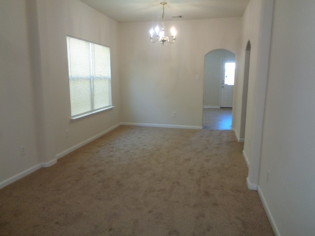 13018 Kingston Point Lane Houston, TX 77047 - Photo 5 of 28 an empty room with chandelier fan and windows