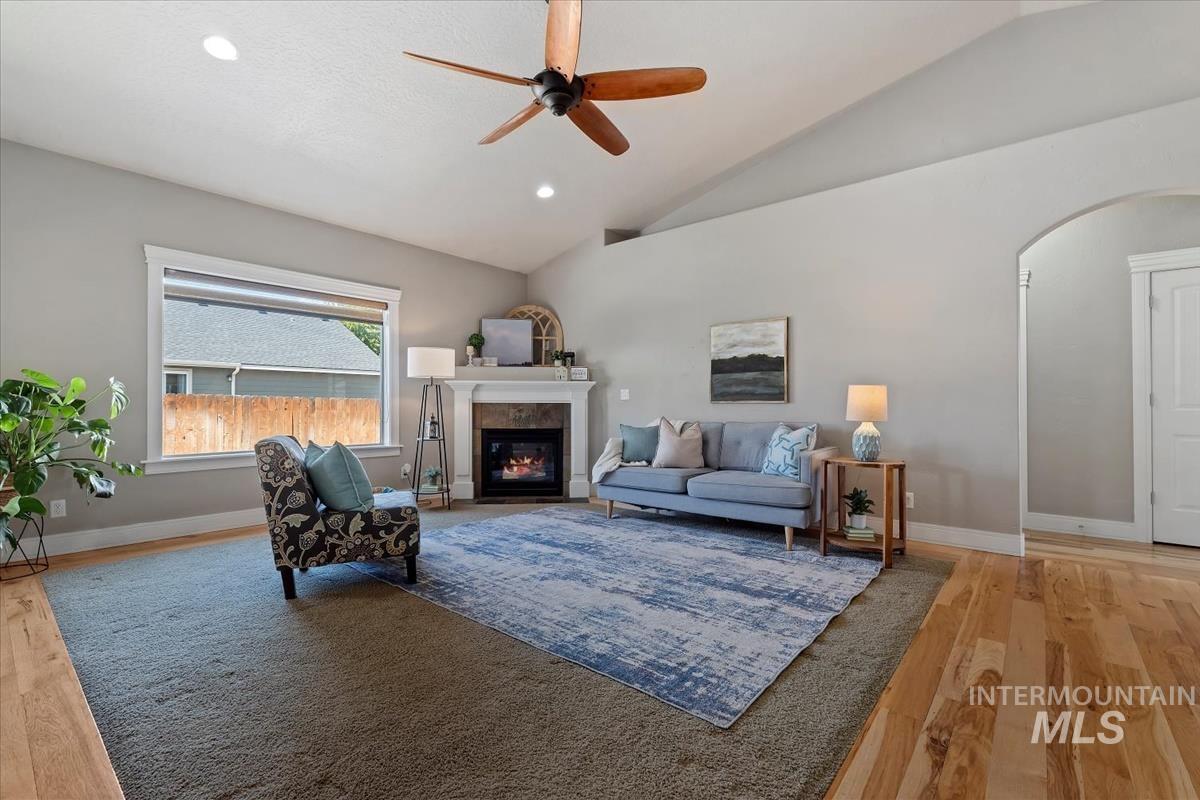640 Southwest Miner Street Mountain Home, ID 83647 - Photo 25 of 35 Living area featuring a vaulted ceiling with a ceiling fan, a fireplace with a white mantel, and recessed lighting