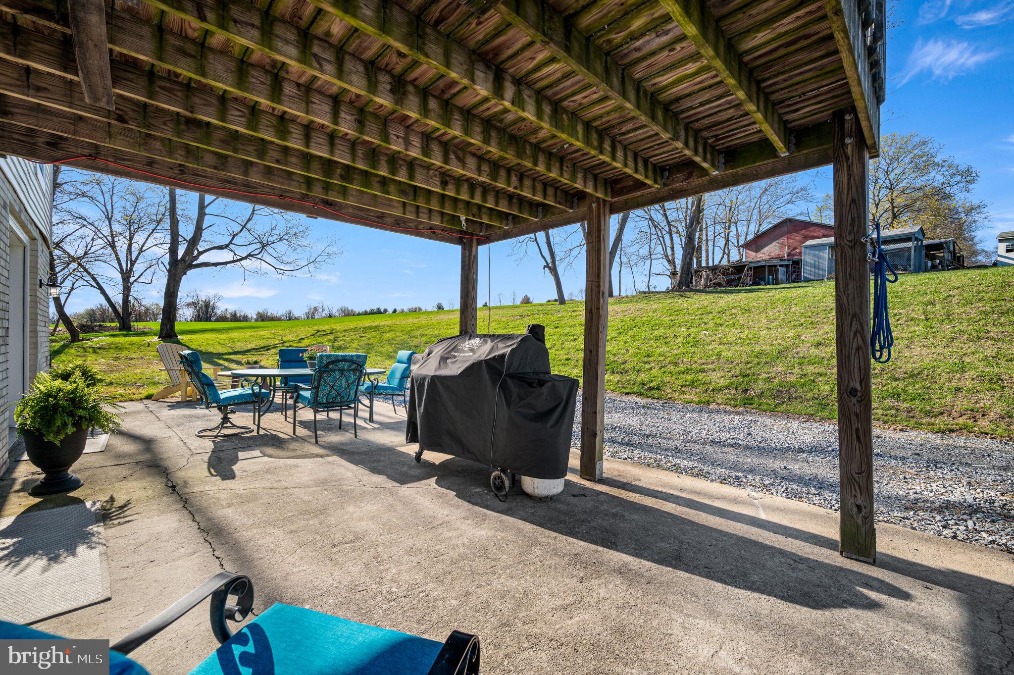 1725 Goosetown Road Coatesville, PA 19320 - Photo 14 of 34 a view of a patio with table and chairs under an umbrella with a patio