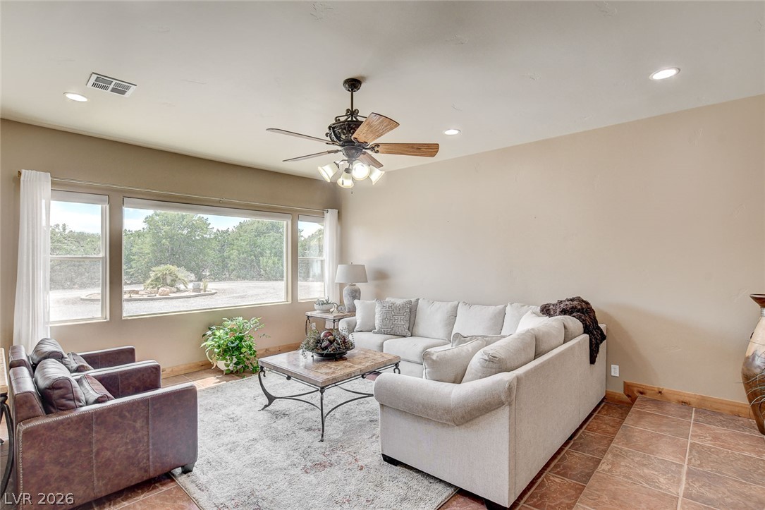 1950 Bowman Road Logandale, NV 89021 - Photo 5 of 98 A relaxed living area boasts a wide window overlooking verdant grounds and a classic ceiling fan for comfort.