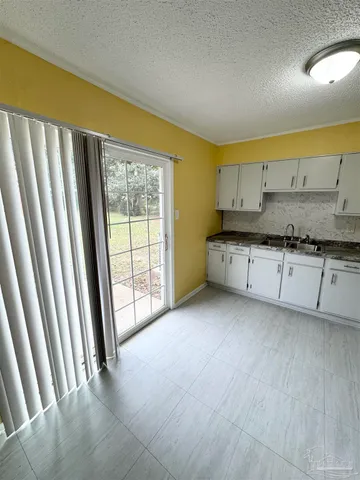 a view of a kitchen with a sink and dishwasher with wooden floor