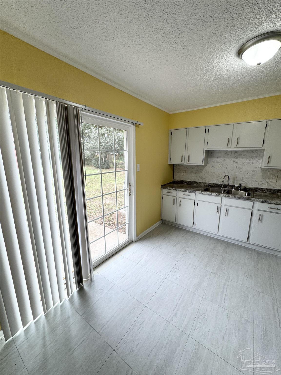 6320 Denver Avenue Pensacola, FL 32526 - Photo 13 of 28 a view of a kitchen with a sink and dishwasher with wooden floor