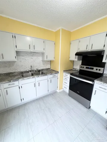 a kitchen with granite countertop a stove a sink and a granite counter tops