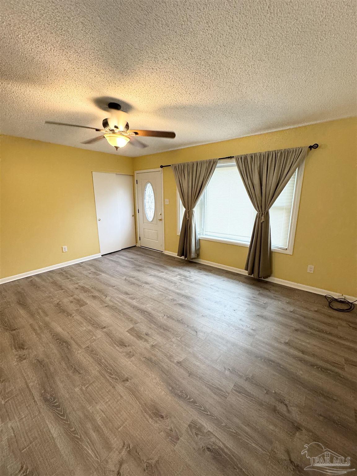 6320 Denver Avenue Pensacola, FL 32526 - Photo 3 of 28 a view of a room with a wooden floor and a ceiling fan