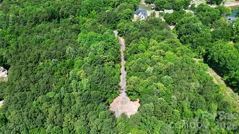 a view of a house with a yard and large trees