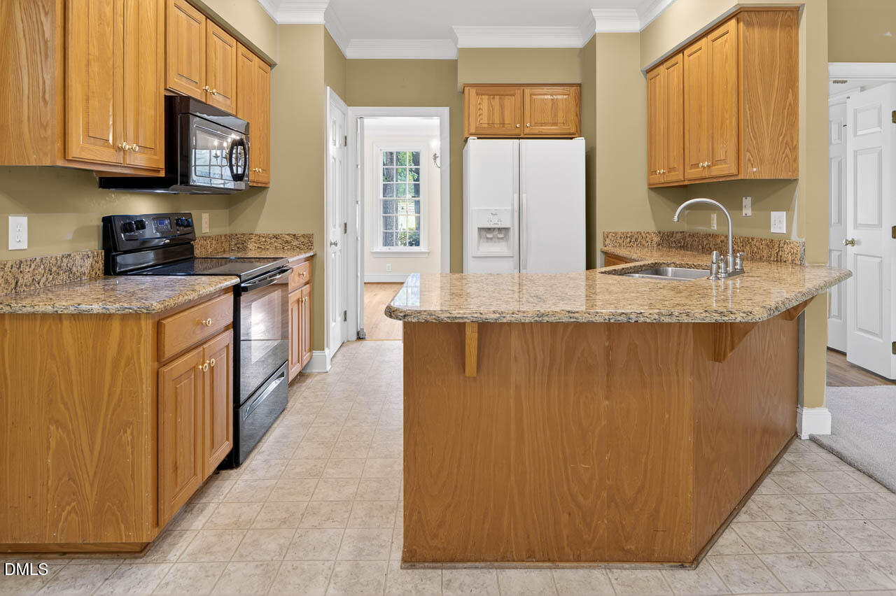 2209 Lodestar Drive Raleigh, NC 27615 - Photo 4 of 50 a kitchen with stainless steel appliances granite countertop a sink a stove and a refrigerator