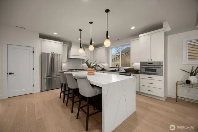 a kitchen with kitchen island a dining table chairs sink and cabinets