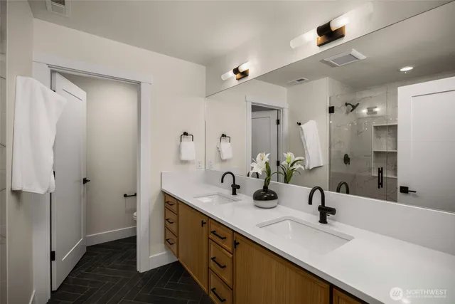 a bathroom with a double vanity sink mirror and shower