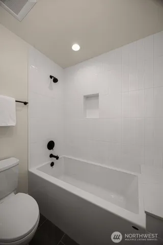 a bathroom with a toilet and a bathtub
