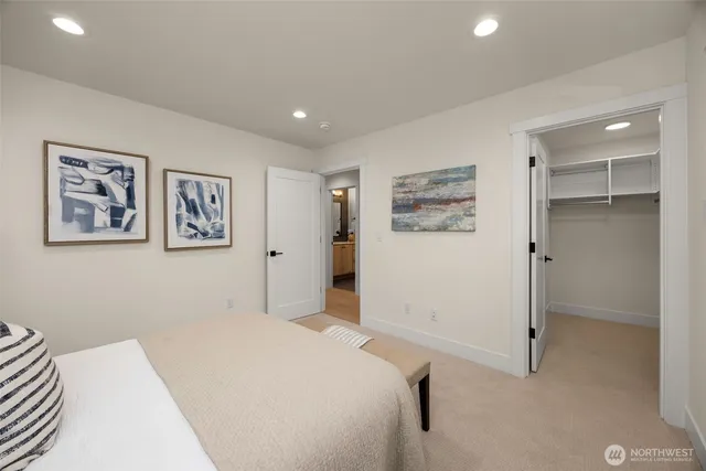 a bedroom with a bed and painting on the wall