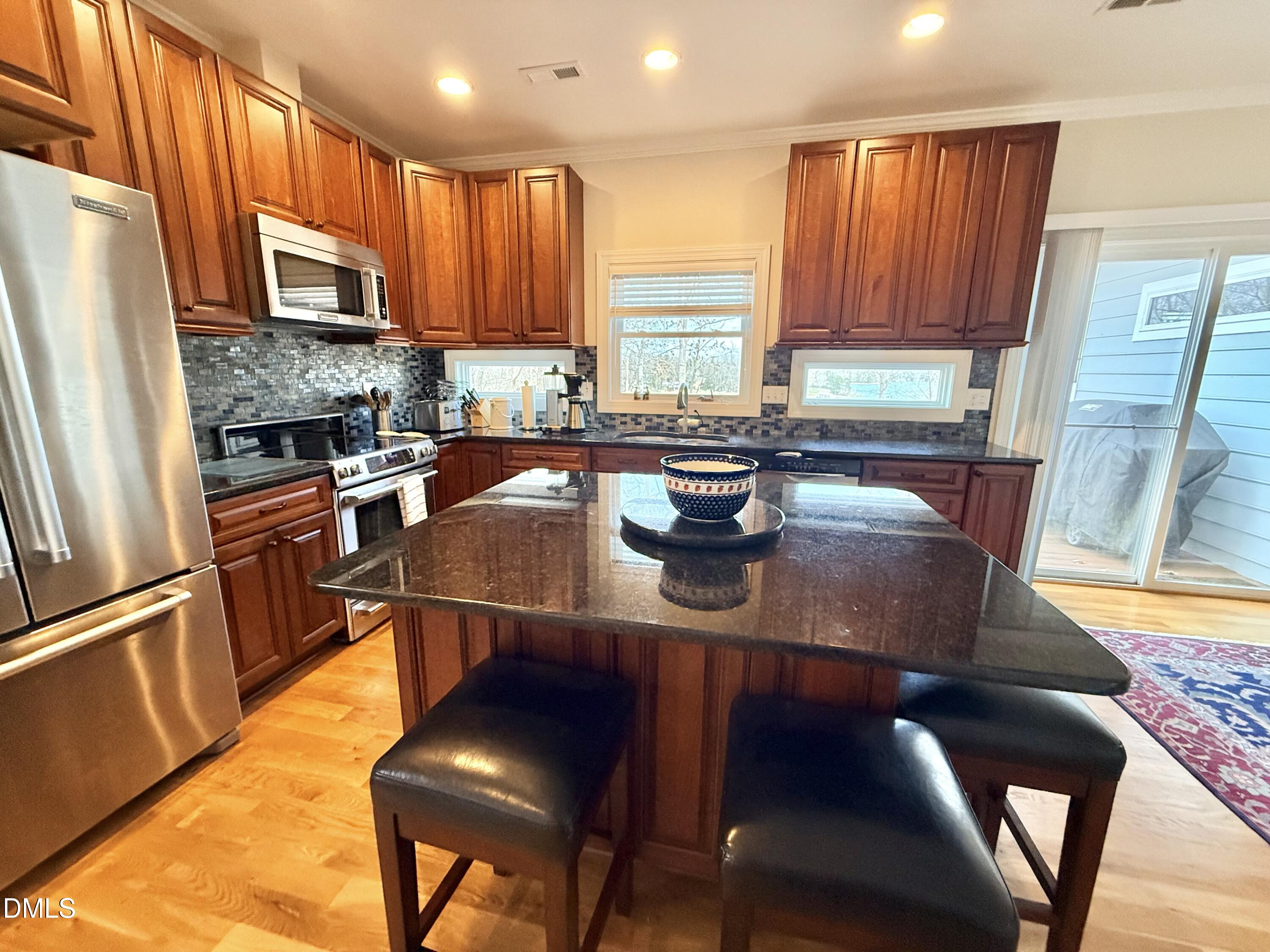 250 Bunny Rabbit Road Leasburg, NC 27291 - Photo 10 of 66 a kitchen with stainless steel appliances granite countertop a sink a stove a table and chairs