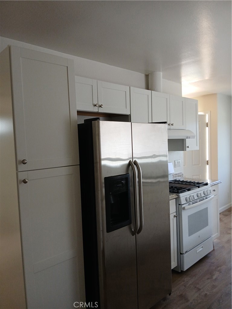 4493 Estada Drive Oceanside, CA 92057 - Photo 12 of 38 a kitchen with stainless steel appliances granite countertop a refrigerator a stove a sink and white cabinets