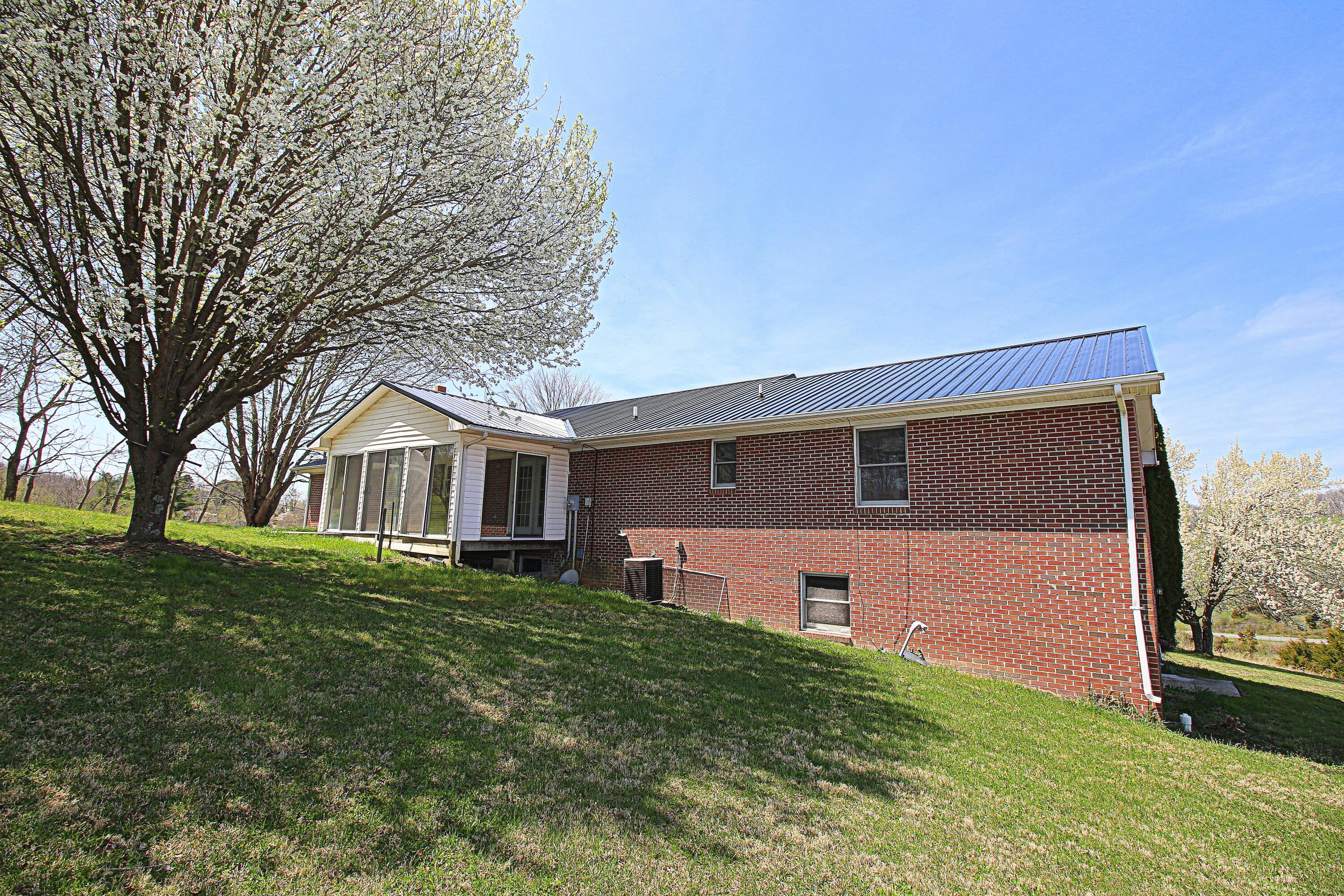 7080 Belspring Road Radford, VA 24141 - Photo 44 of 53 a front view of house with yard and trees in the background