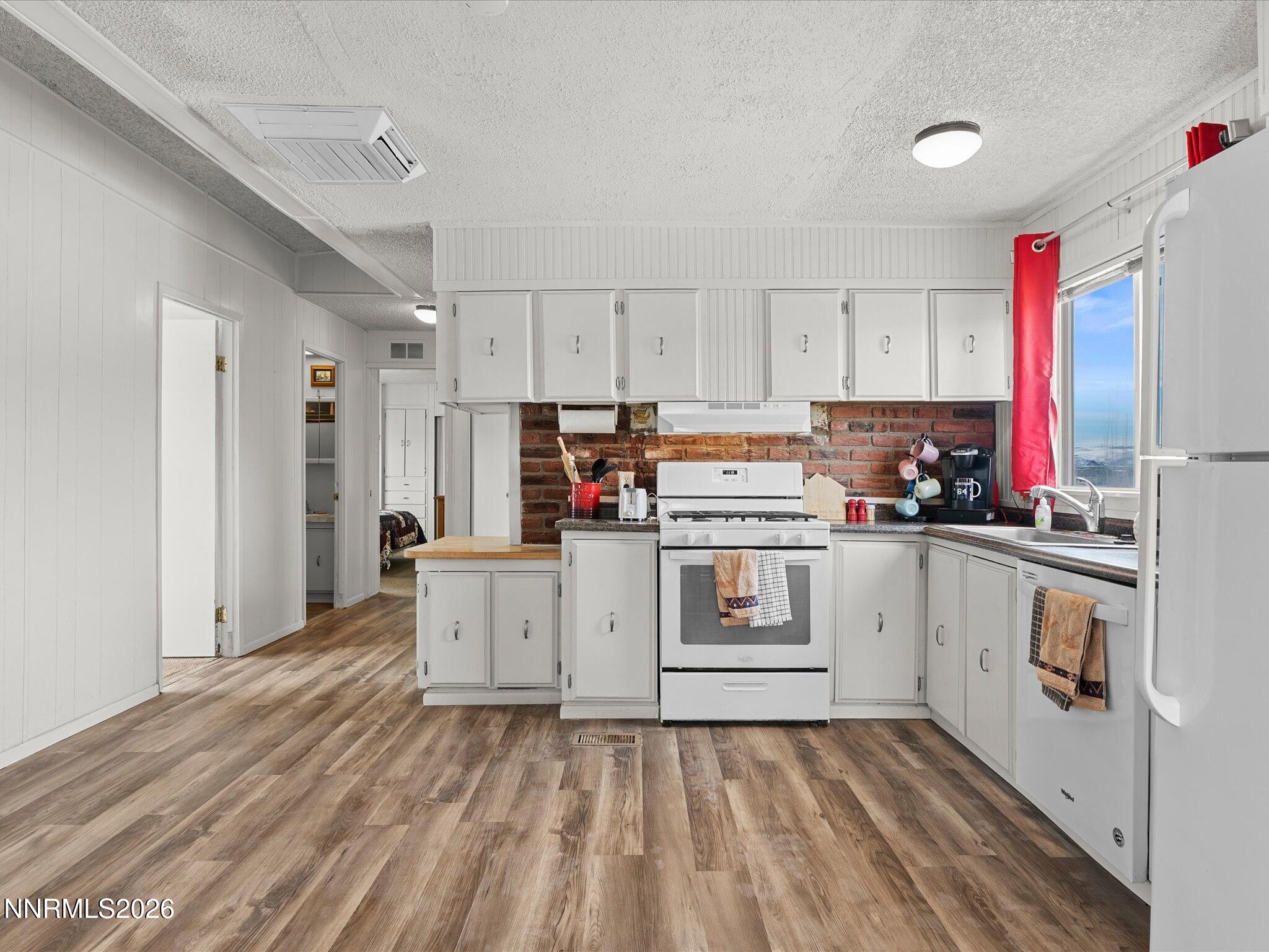 7815 Springfield Road Silver Springs, NV 89429 - Photo 13 of 46 a kitchen with granite countertop white cabinets and white appliances