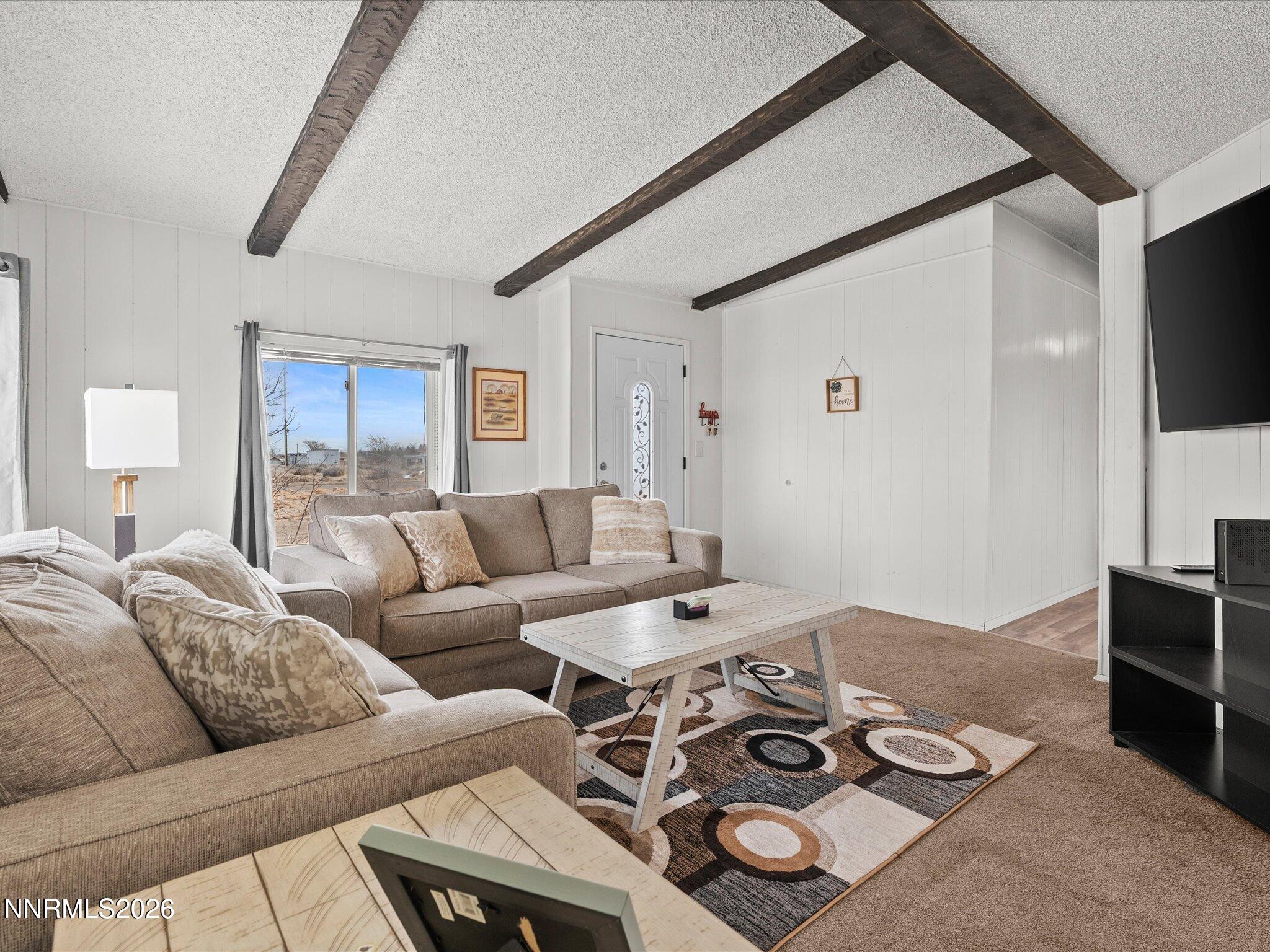 7815 Springfield Road Silver Springs, NV 89429 - Photo 9 of 46 a living room with furniture a flat screen tv and a refrigerator