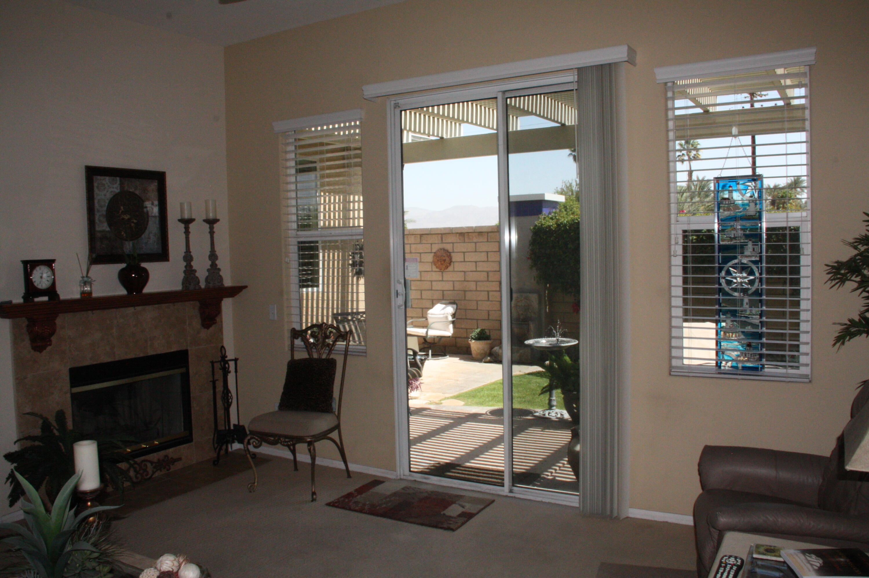 49758 Lewis Road Indio, CA 92201 - Photo 24 of 47 a living room with furniture a fireplace and a floor to ceiling window