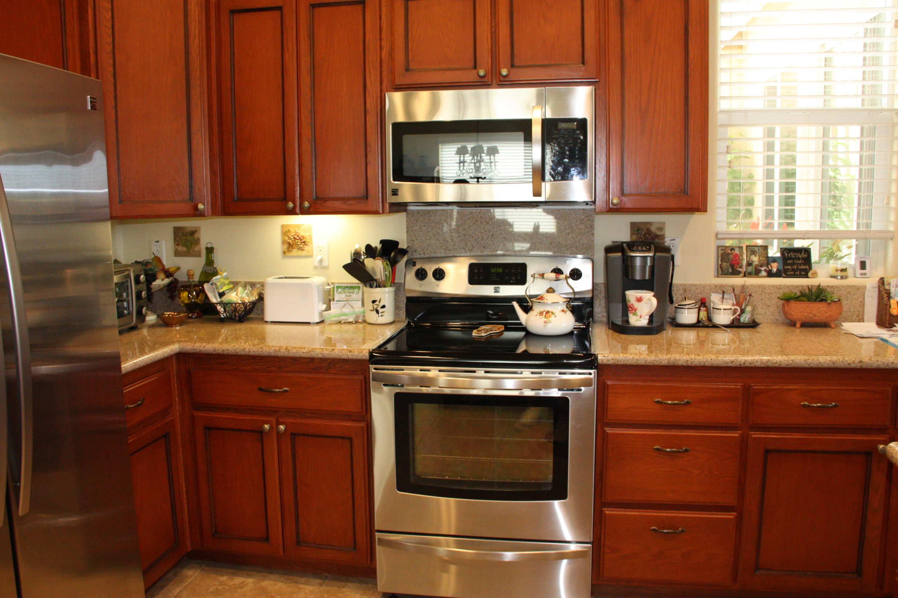 49758 Lewis Road Indio, CA 92201 - Photo 28 of 47 a kitchen with stainless steel appliances granite countertop wooden cabinets stove top oven and sink