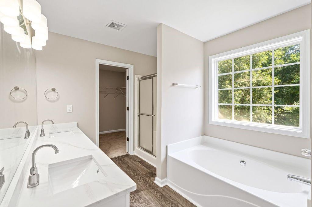473 Greyhawk Way Fairburn, GA 30213 - Photo 24 of 34 a bathroom with a tub sink and mirror