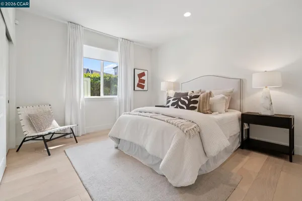 a bedroom with a bed chair and a window