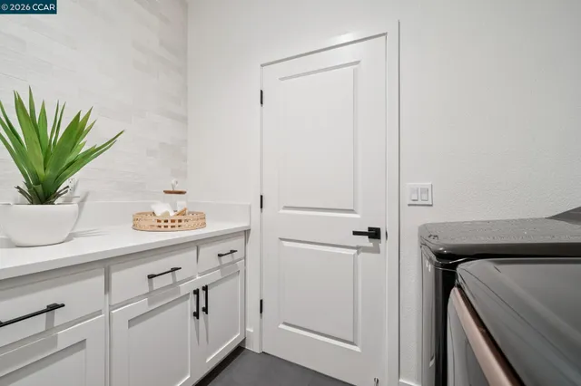 a utility room with cabinets and wooden floor