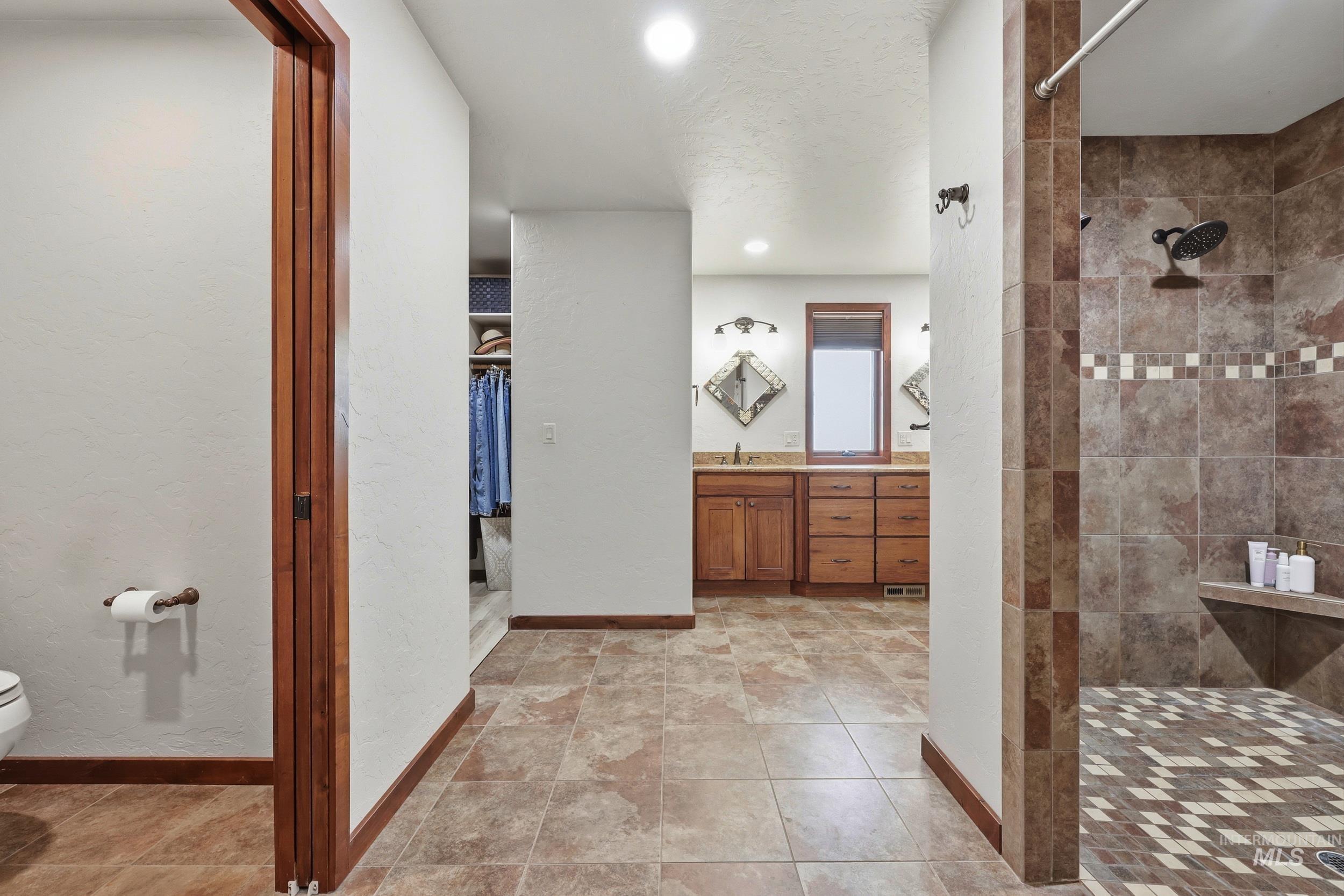339 Airport Road Weiser, ID 83672 - Photo 28 of 49 Tiled bathroom flooring leading to a spacious walk-in shower with a built-in bench