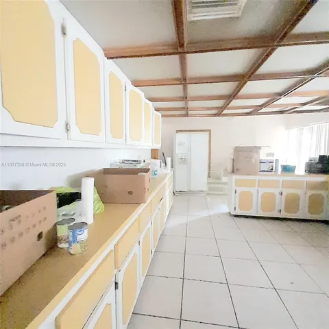 a kitchen with stainless steel appliances granite countertop a sink and white cabinets next to a window