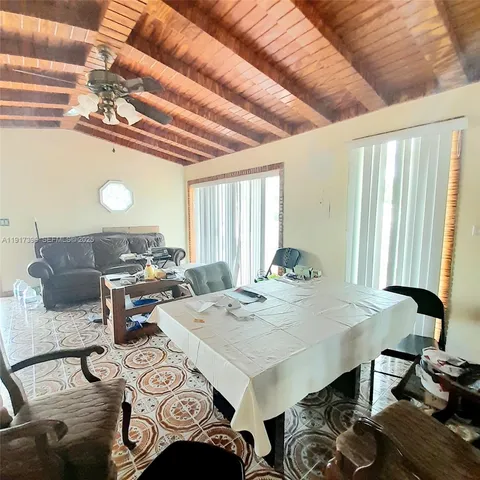 a view of a dining room with furniture and a chandelier